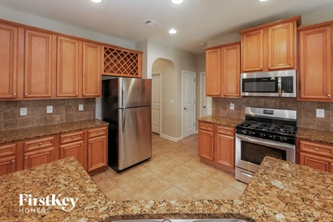 A kitchen with wooden cabinets and a granite countertop.